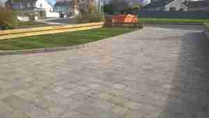 Image of new driveway block paved, and raised turf lawn Front garden design