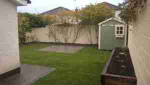 Picture of limestone patio, turf lawn and raised sleeper bed