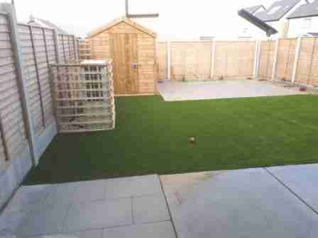 Image of low maintenance garden with artificial lawn and silver granite textured patio slabs