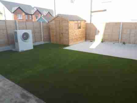 Image of low maintenance garden with artificial lawn and silver granite textured patio slabs