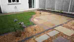 Image of lawn,New Limestone curved patio with cobble insets and plants