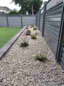 Image of Elite fence, a low maintenance fence gravel border with cottage perennials and decorative gravel mulch