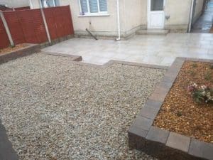 Porcelain paving and retaining wall & beds , gravel replacing lawn