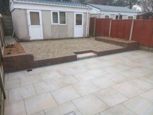 Porcelain paving and retaining wall & beds , gravel replacing lawn