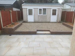 Porcelain paving and retaining wall & beds , gravel replacing lawn