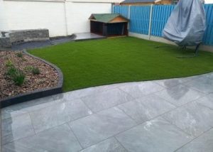 Low maintenance garden, artificial lawn , patio and raised flower bed